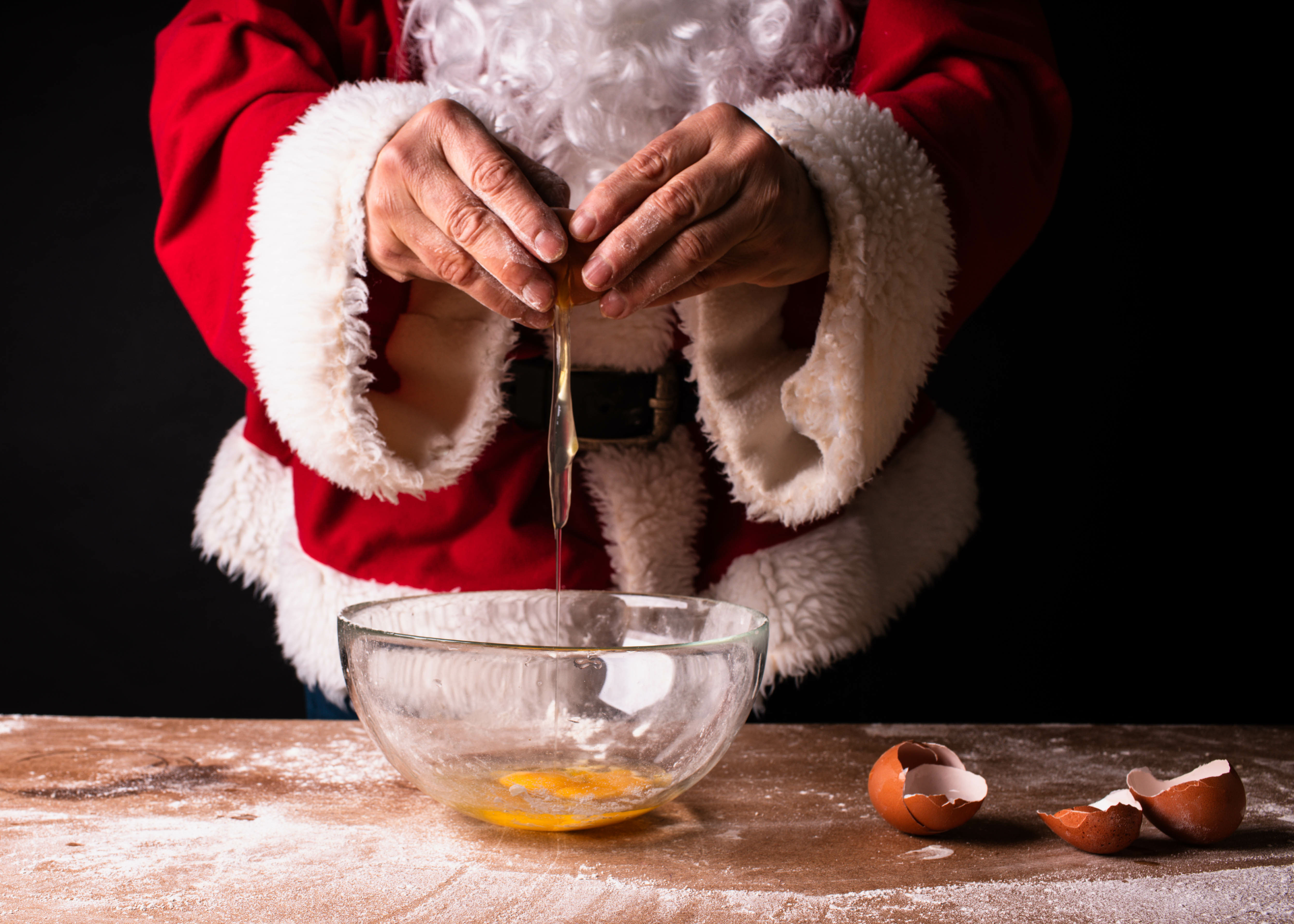 Santa Claus cracking an egg getting ready for a dinner